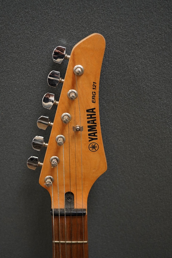 A Yamaha ERG121 electric guitar in black finish, with a soft gig case